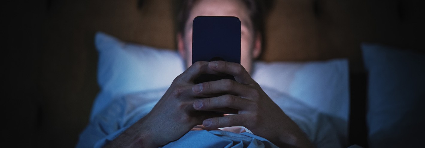 Woman in bed on her phone